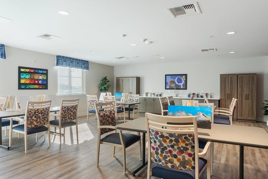 A modern dining area with neatly arranged tables and chairs, featuring bright lighting and contemporary decor.