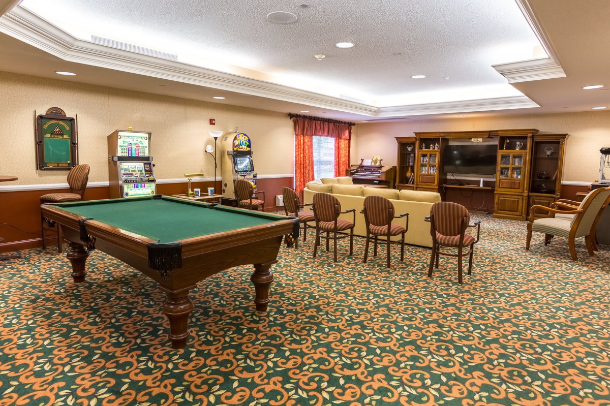 A spacious recreation room features a pool table, seating area, and entertainment center.