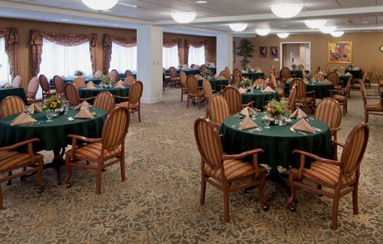 An elegantly decorated dining room with round tables and upholstered chairs.