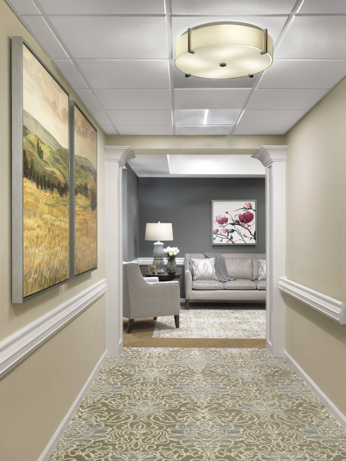 A well-lit office hallway featuring a cozy seating area with elegant decor.