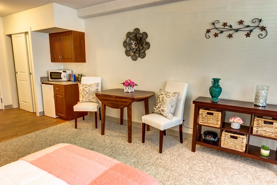 A cozy living space with a small dining area and kitchenette, featuring elegant decor.