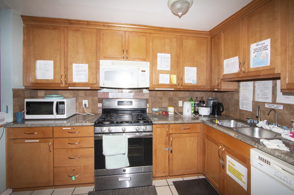 A kitchen with wooden cabinets, a microwave, and an oven.