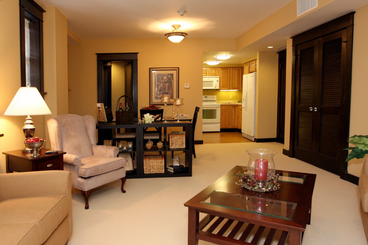 A cozy living space featuring a combined living room, dining area, and kitchen with warm lighting and comfortable furnishings.