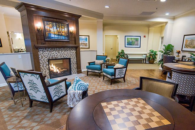 A cozy lobby seating area with a fireplace and chess table.