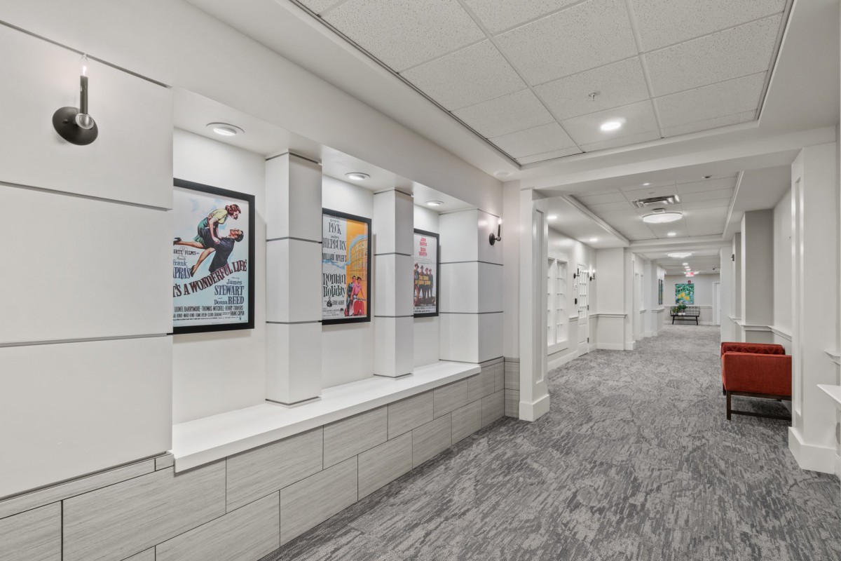 A modern hallway featuring framed posters and stylish lighting.