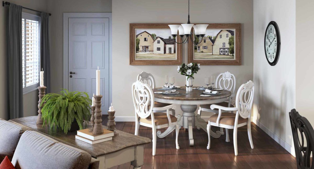 A cozy dining room with elegant white chairs and a round wooden table, adorned by a decorative chandelier and charming wall art.