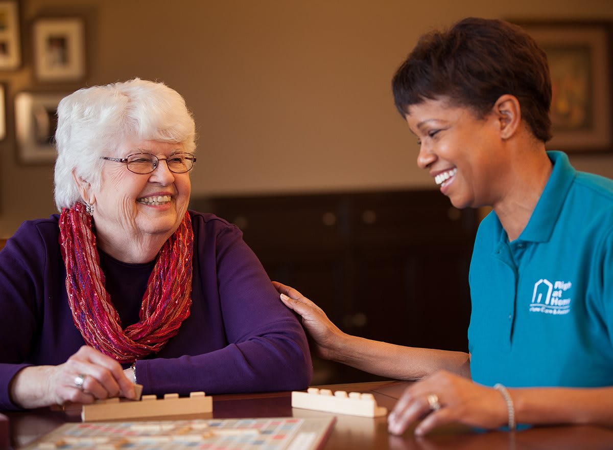 Two people smiling and engaged in a board game.