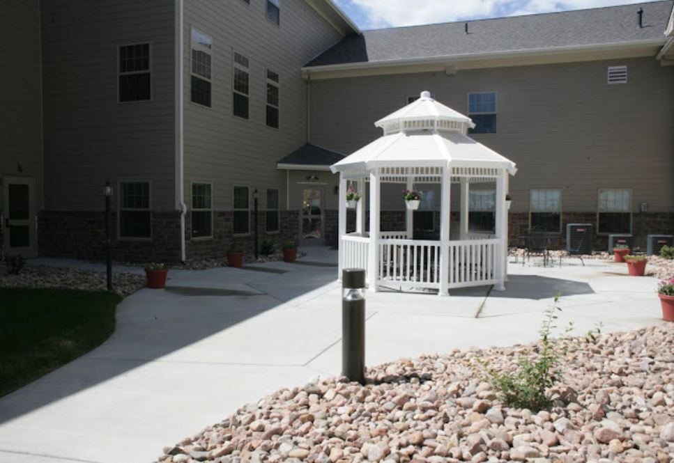 A courtyard featuring a white gazebo surrounded by a building.