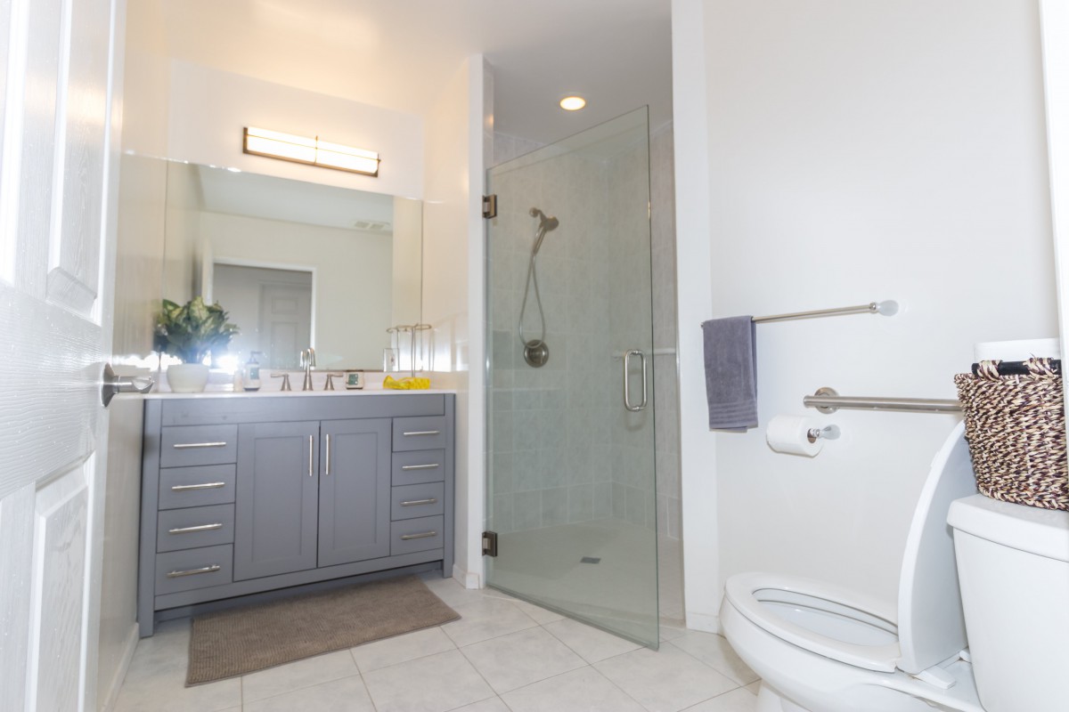 A modern bathroom with a sleek vanity, glass shower, and contemporary fixtures.