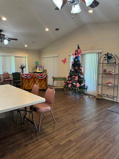A cozy community center space decorated for the holidays, featuring a Christmas tree and seating arrangements.