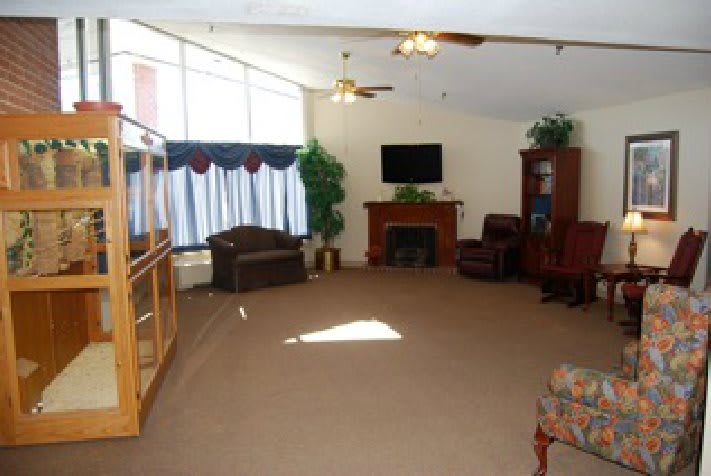 A spacious living room with a fireplace, television, and large windows.