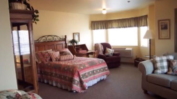 Cozy bedroom with a large bed and seating area near the window.