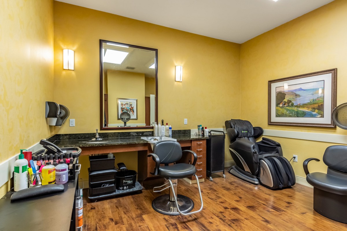 A cozy hair salon with a barber chair and a massage chair.
