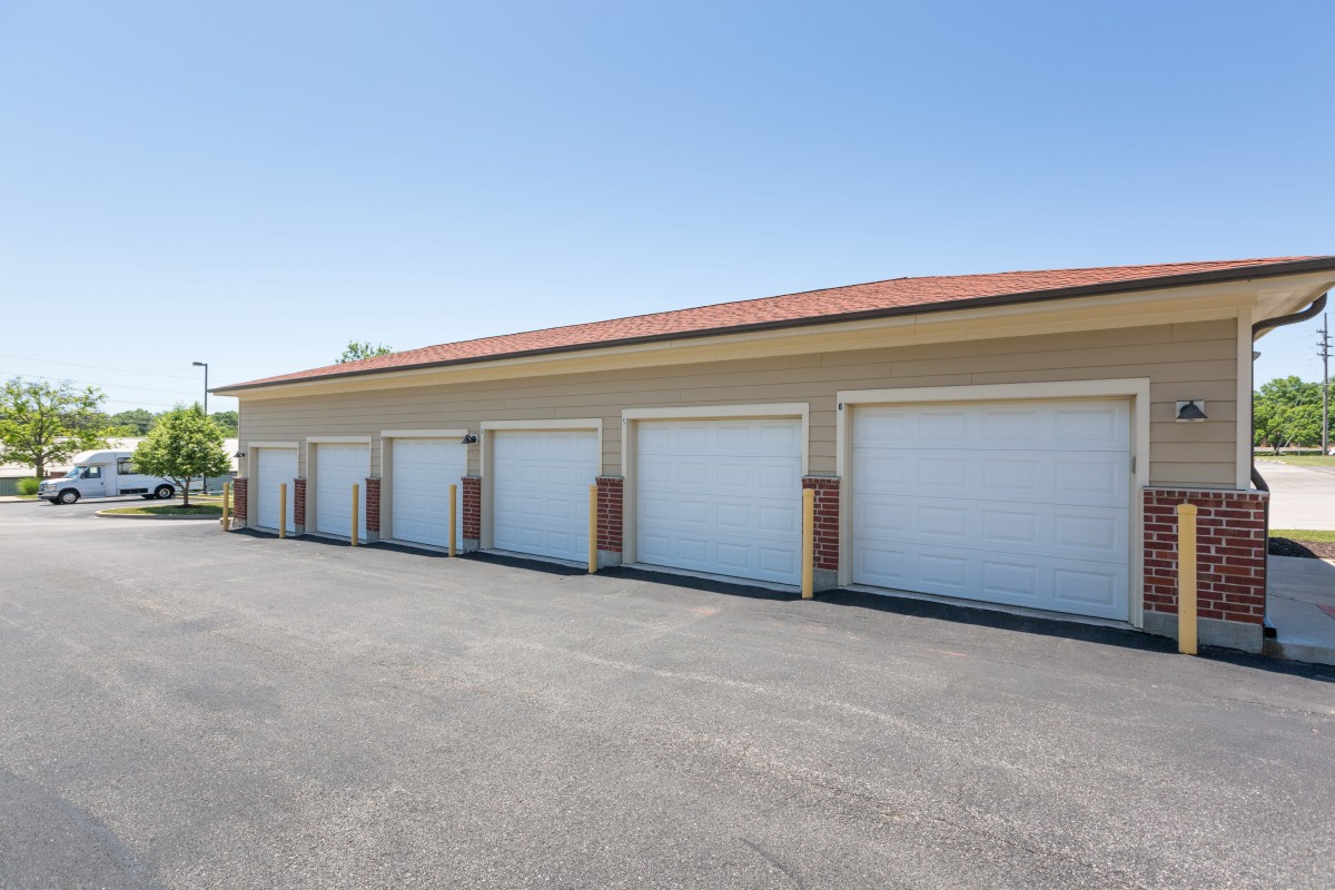 Row of closed storage unit garage doors in an outdoor facility.