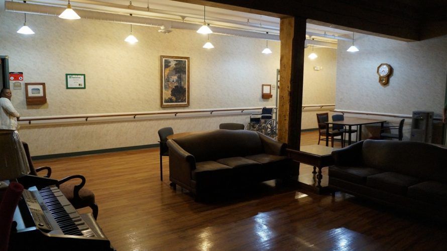 A cozy lounge area featuring a sofa, wooden flooring, and wall artwork.