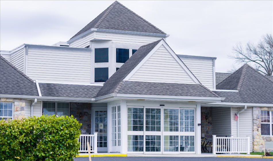 A modern residential house with large windows and a complex roof design.