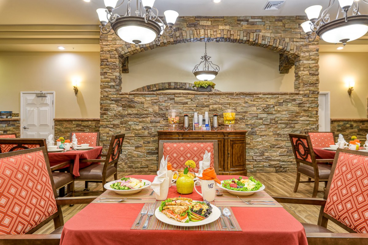 A cozy restaurant setting with a dining table beautifully set for a meal, featuring warm lighting and elegant decor.