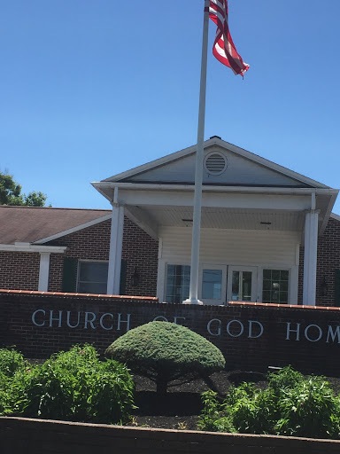 The Church of God Home, featuring a flag and well-maintained landscaping.