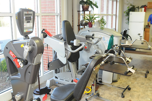 A well-equipped gym area featuring various exercise machines for fitness and rehabilitation.