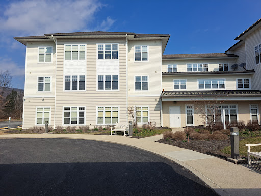 A modern residential building with multiple stories and a spacious parking entrance.
