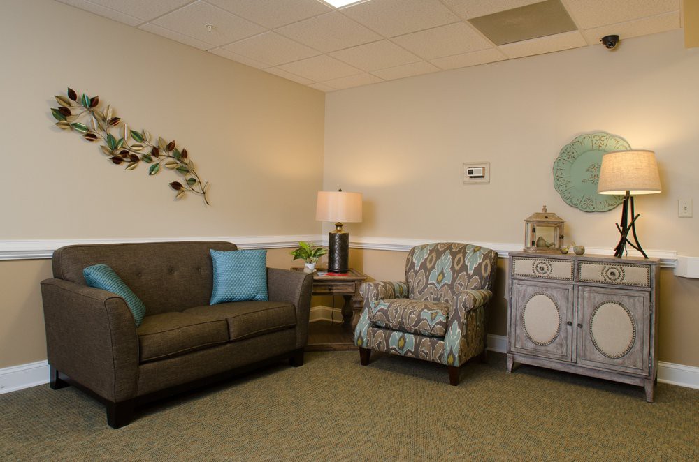 A cozy living room with a sofa, armchair, and decorative elements.