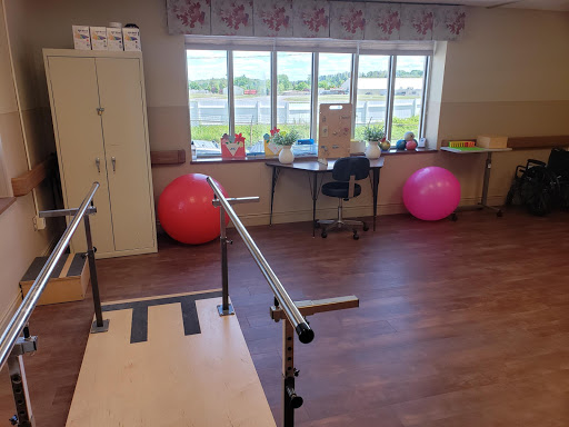 A well-equipped therapy room featuring balance bars and exercise balls, designed for rehabilitation and fitness activities.