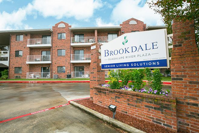 A senior living facility with a prominent sign and brick exterior.