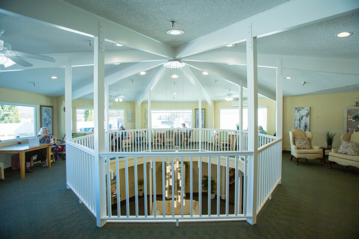 An interior view of a building featuring a dome ceiling and white railing surrounding an open space.