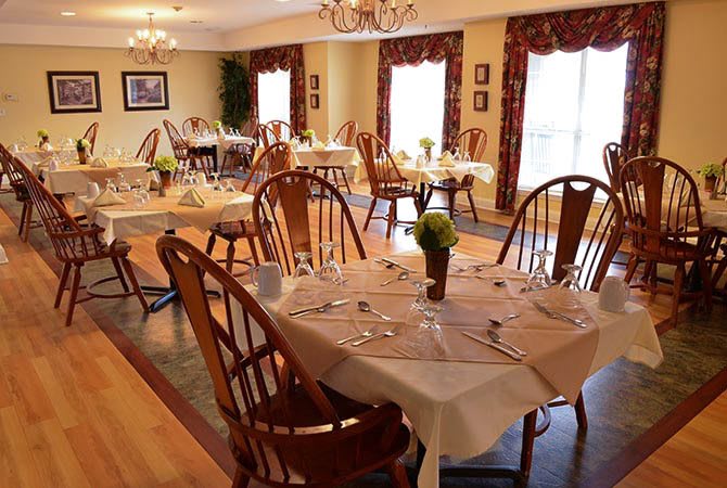 An elegantly decorated dining room with neatly arranged tables and chairs.