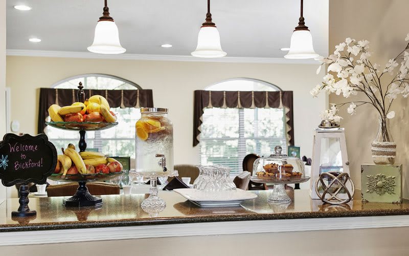 A cozy kitchen counter with fruit displays and charming decor.