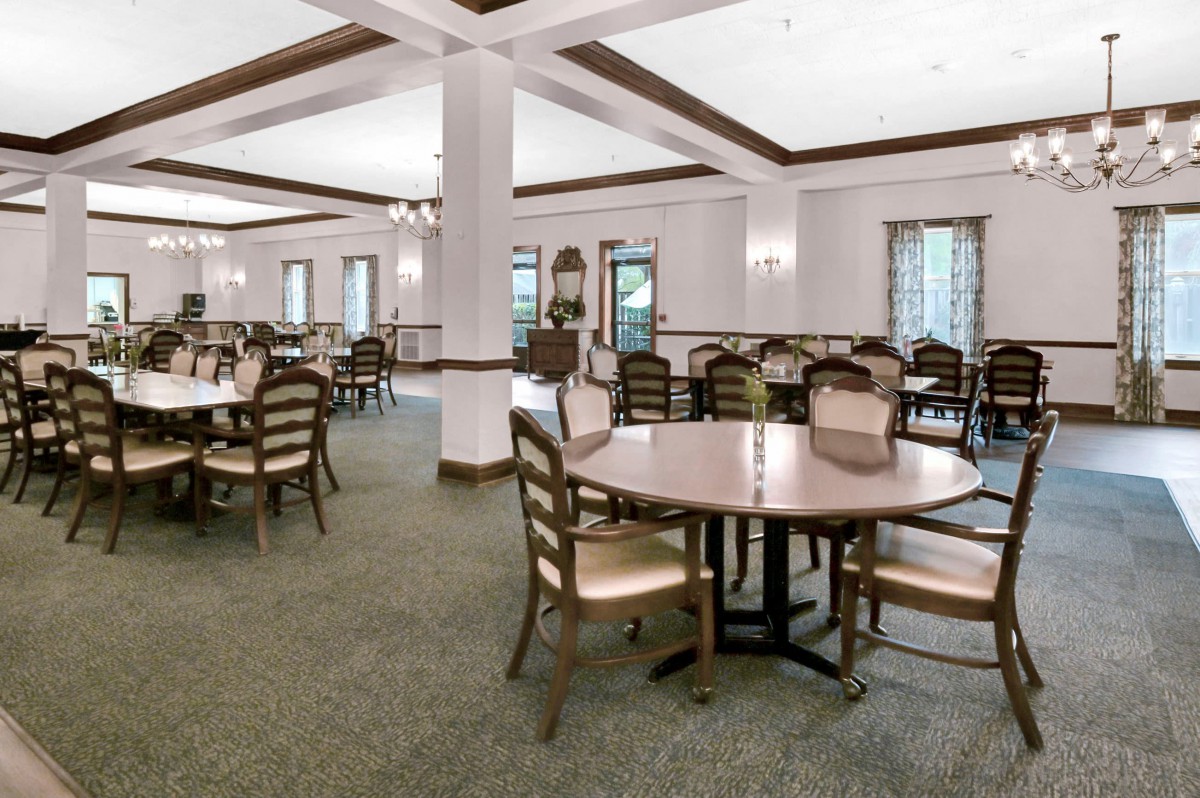 A spacious and well-lit dining area with neatly arranged tables and chairs.