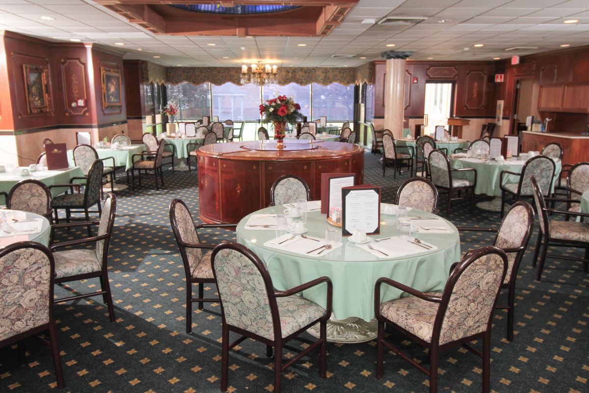 An elegant dining room with neatly arranged tables and chairs, featuring a classic interior design.
