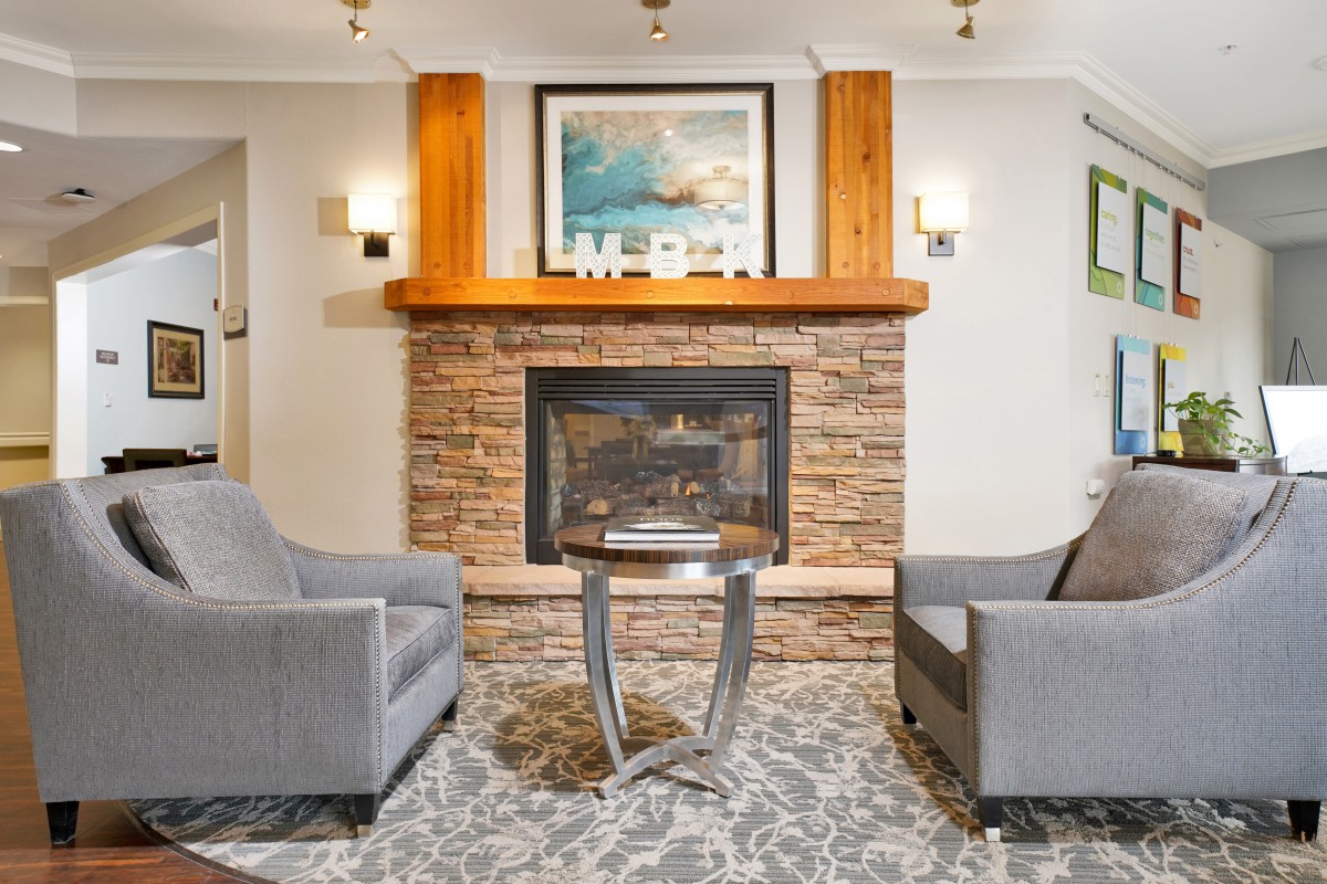 A cozy living room with a stone fireplace and modern furniture.