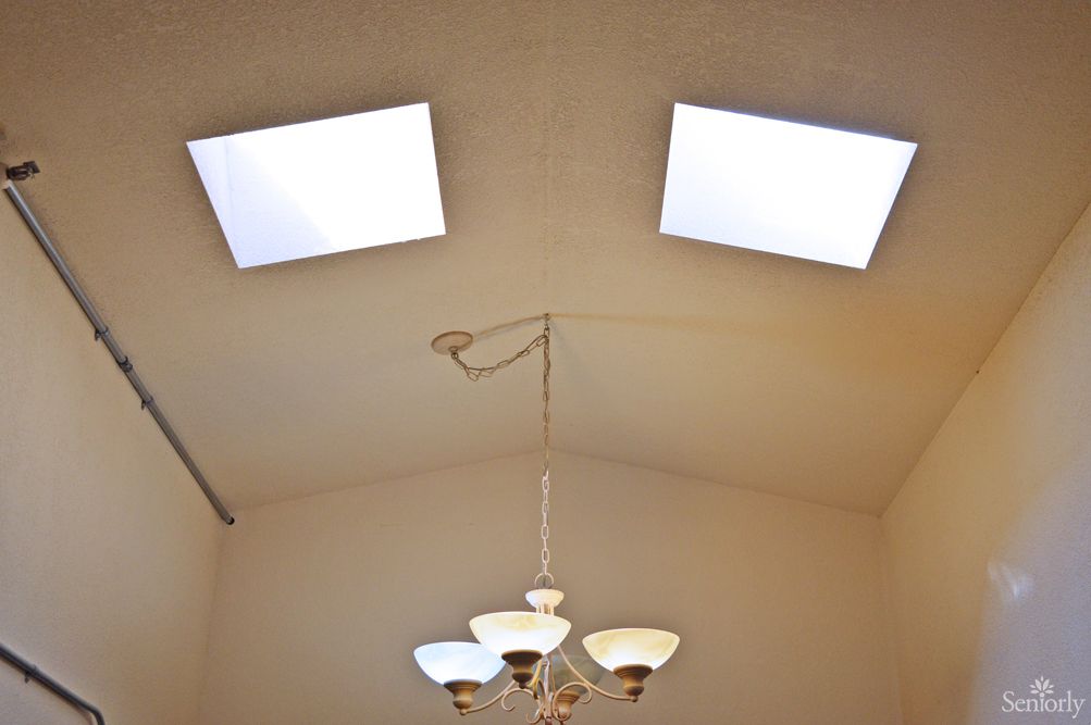 A ceiling with two square light fixtures and a decorative hanging lamp.