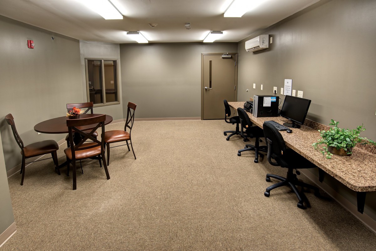 A small office space with computer workstations and a table with chairs.