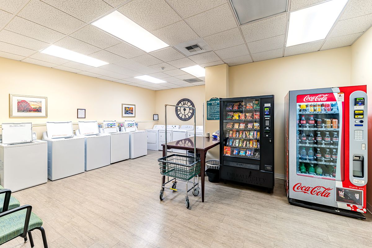 A laundromat with washing machines and vending machines for snacks and drinks.