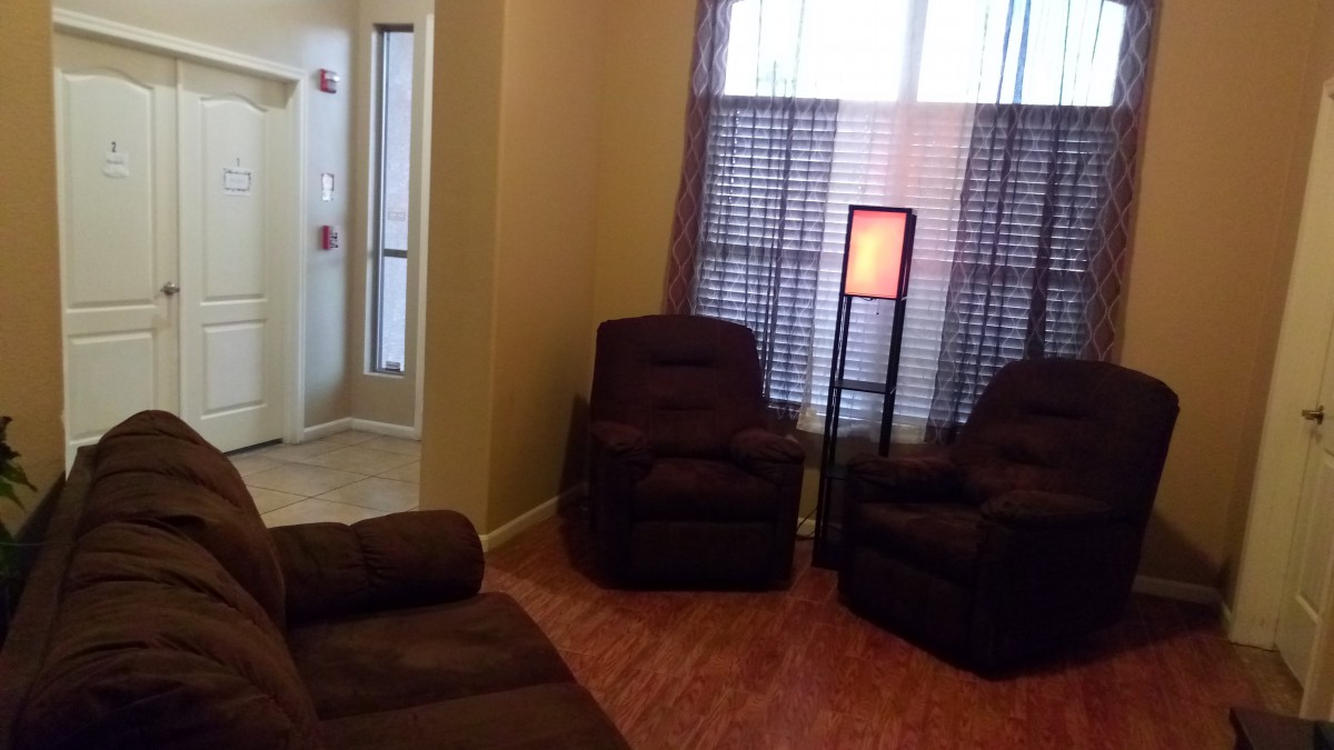 A cozy living room with plush chairs and a standing lamp.