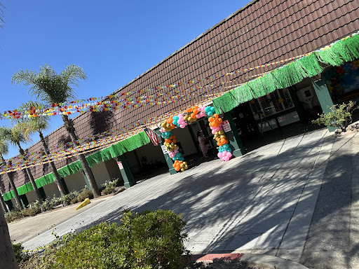 A beautifully decorated building entrance, adorned with colorful flowers and greenery, ready for a festive event.