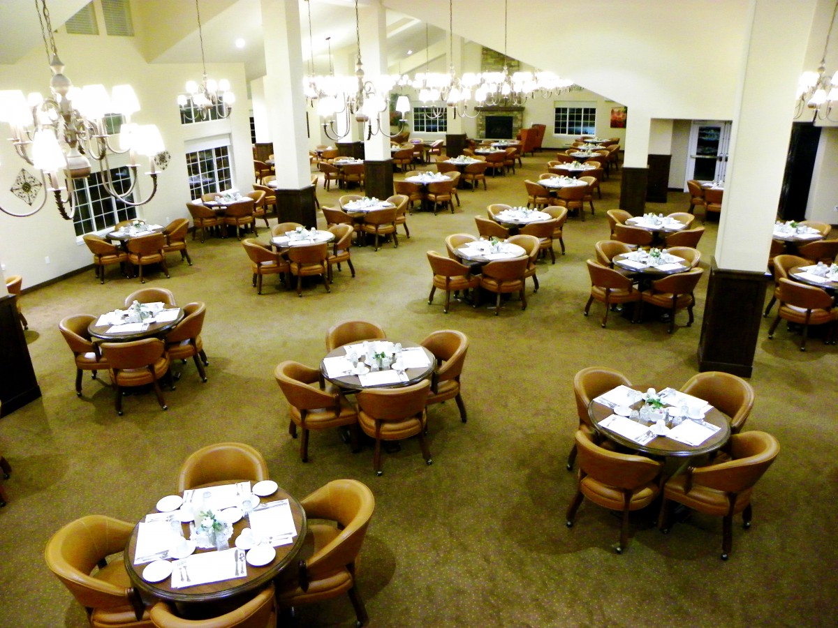 An empty restaurant dining area with neatly arranged tables and chairs.