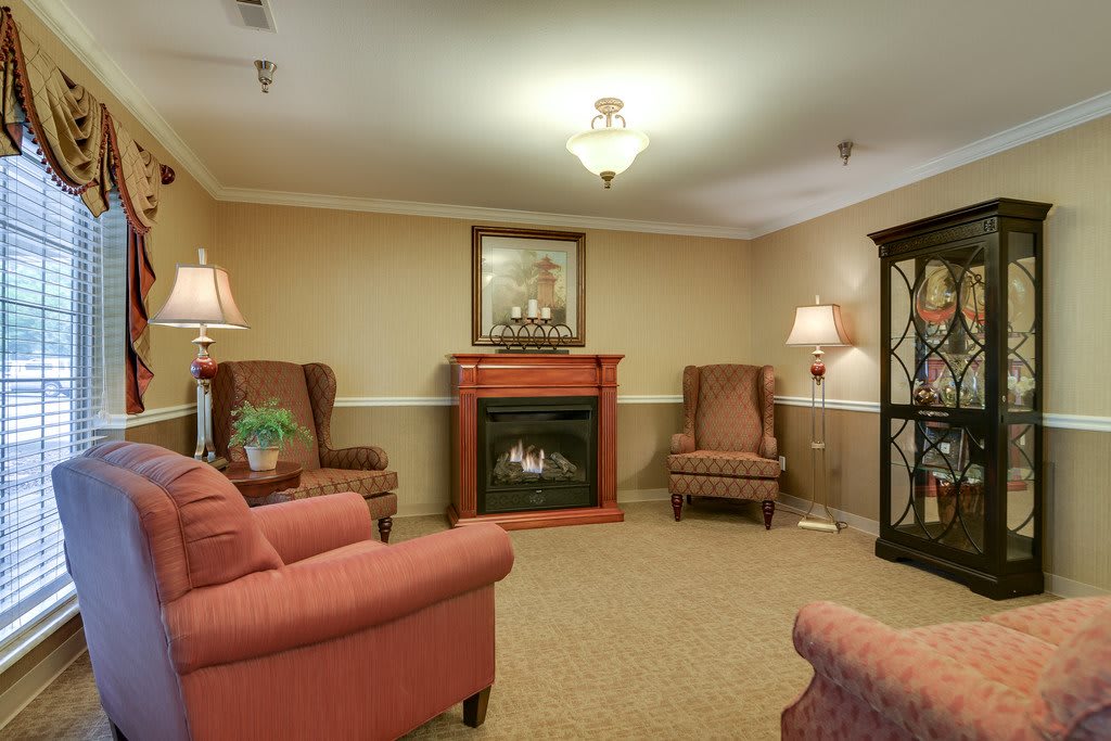A cozy living room featuring comfortable armchairs, a fireplace, and warm lighting.