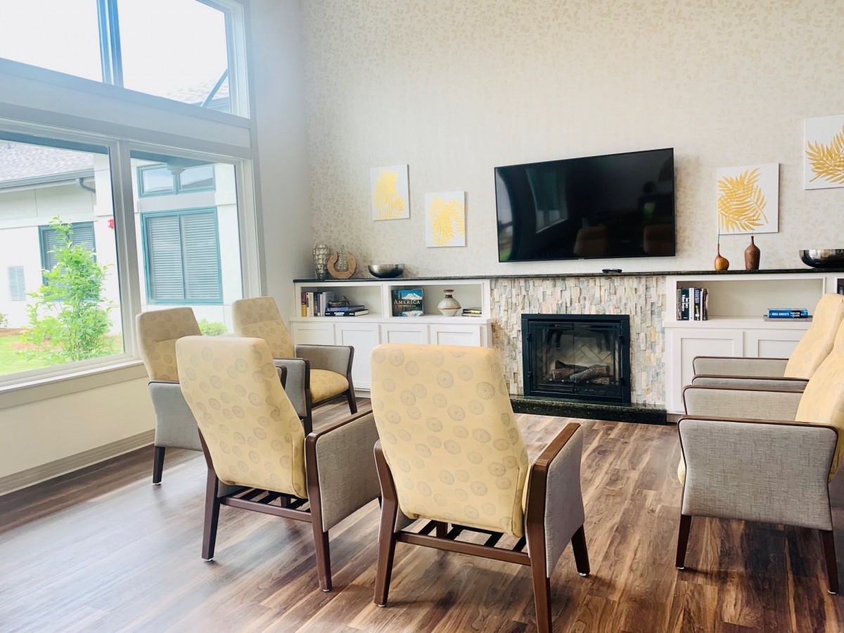 A modern living room with a fireplace and television, featuring comfortable seating and stylish decor.