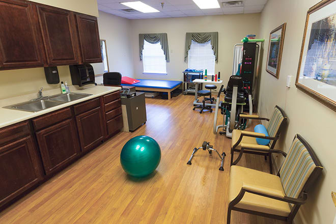 A physical therapy room equipped with exercise equipment and a gym ball.