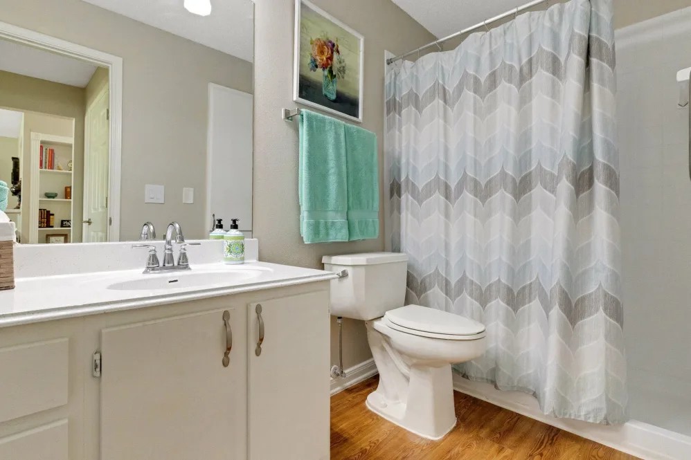 A modern bathroom with a sink, toilet, and shower area.