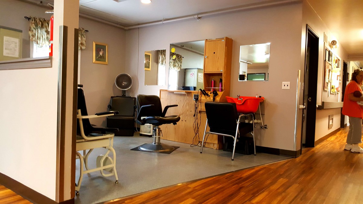 A cozy hair salon interior with chairs, mirrors, and equipment.