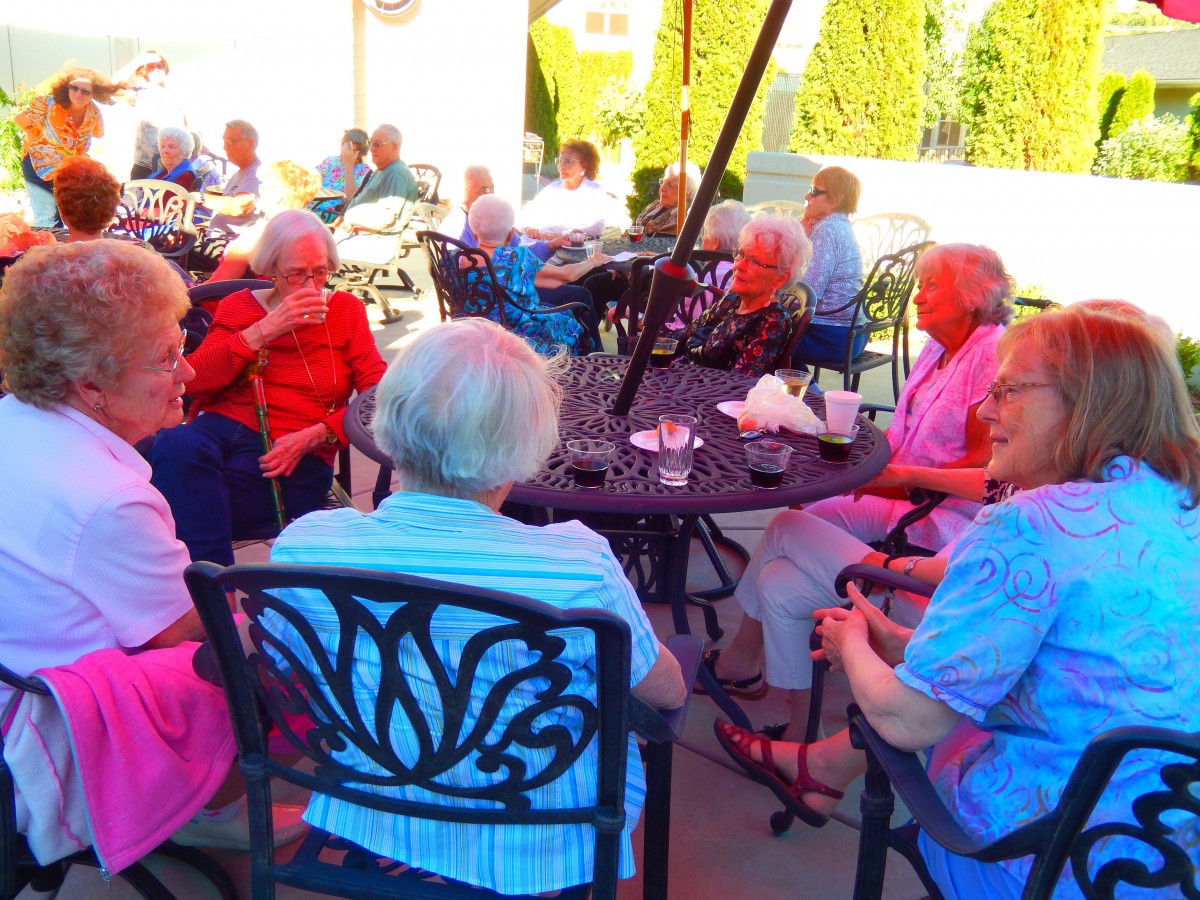 A group of seniors enjoying a social gathering on a sunny patio.