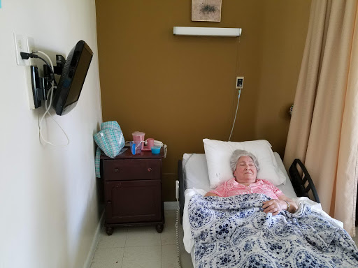A patient resting in a hospital room, surrounded by care essentials.