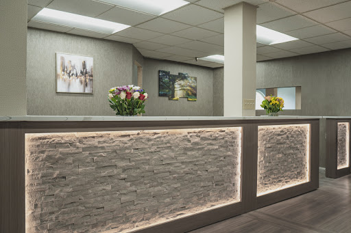 A modern reception area featuring elegant floral arrangements and contemporary artwork on the walls.