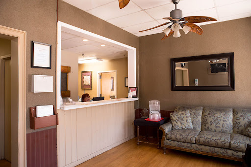 A welcoming reception area featuring a cozy seating arrangement and a ceiling fan.