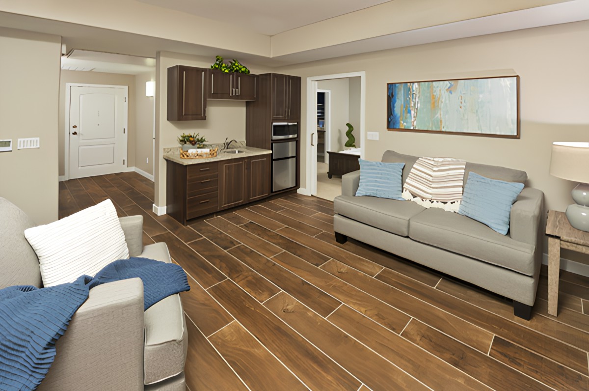 A modern open-concept living room and kitchen area with wooden floors and stylish decor.