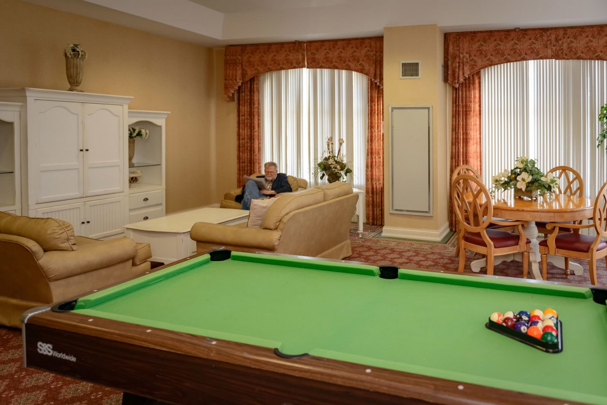 A cozy living room with a pool table and comfortable seating area.